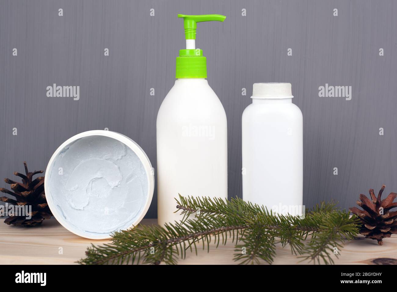 cosmétiques naturels sur fond gris avec branches et cônes de sapin, espace de copie. soins du corps et du visage de beauté. Banque D'Images