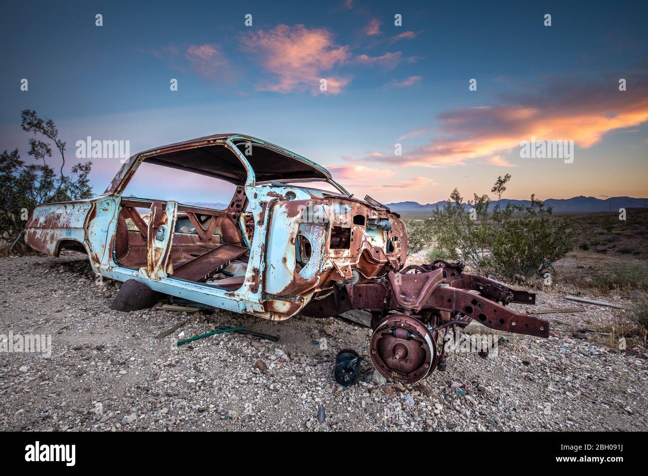 Une berline naufragé et rouillée dans la ville fantôme de Rhyolite, dans la vallée de la mort, au coucher du soleil Banque D'Images
