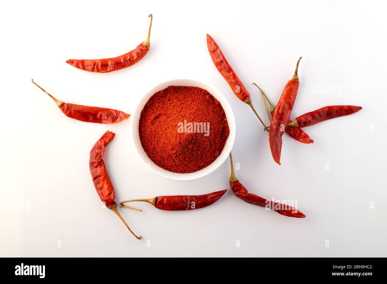 chilis rouge avec poudre de froid rouge sur fond blanc Banque D'Images