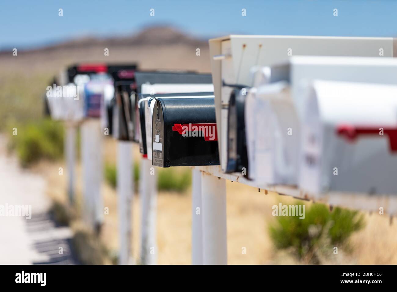 Gros plan sur une rangée de boîtes aux lettres américaines traditionnelles emblématiques, dans un paysage désertique Banque D'Images