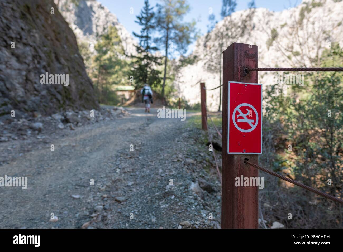 Panneau « non fumeur » dans le parc naturel avec un hiker flou non reconnaissable en arrière-plan. "Journée dans la nature avec signe le long du chemin de randonnée." Banque D'Images Panneau « non fumeur » dans le parc naturel avec un hiker flou non reconnaissable en arrière-plan. "Journée dans la nature avec signe le long du chemin de randonnée." Banque D'Images