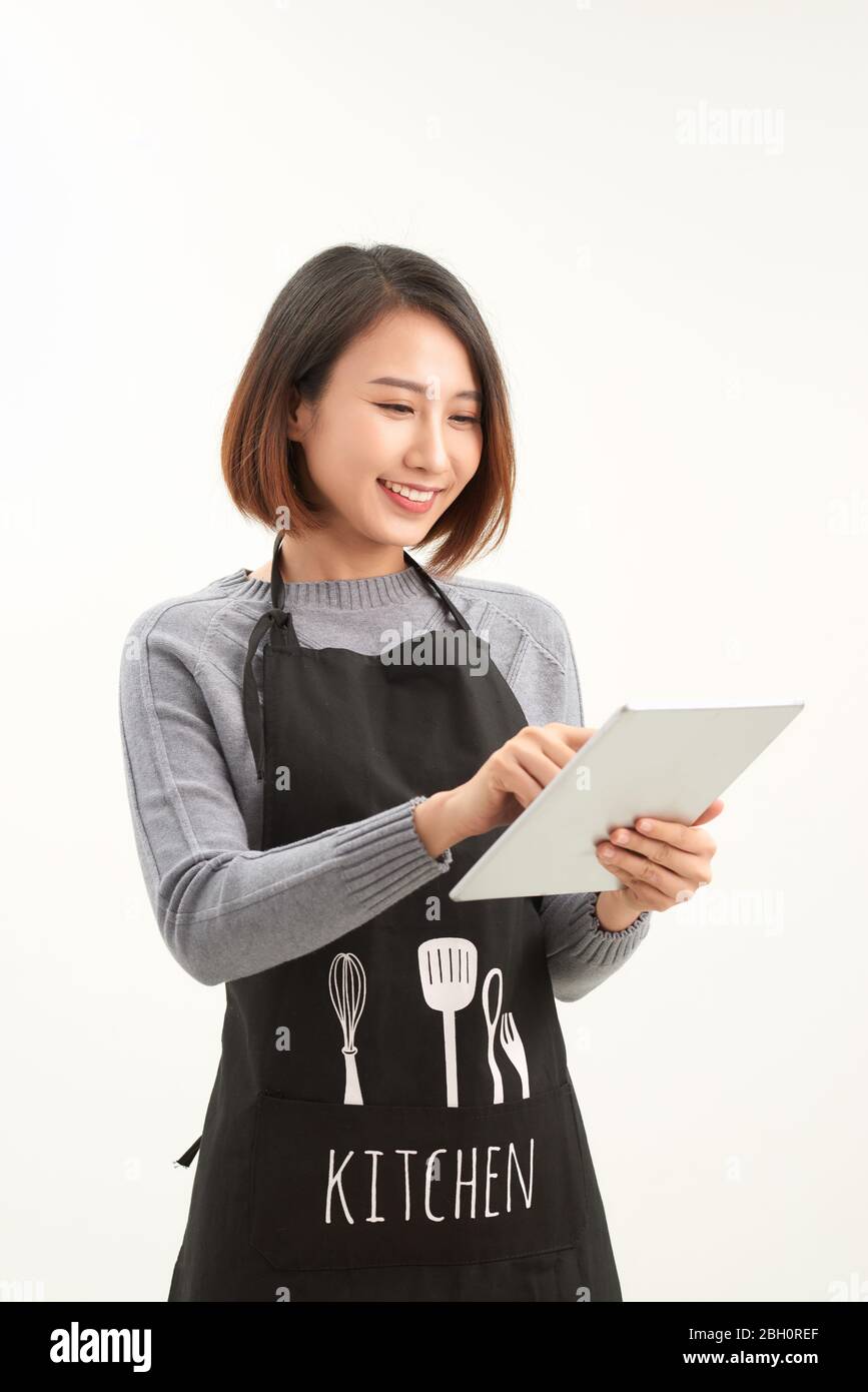 Employé de l'hypermarché avec tablier noir tenant une tablette moderne isolée sur fond blanc avec copyspace Banque D'Images