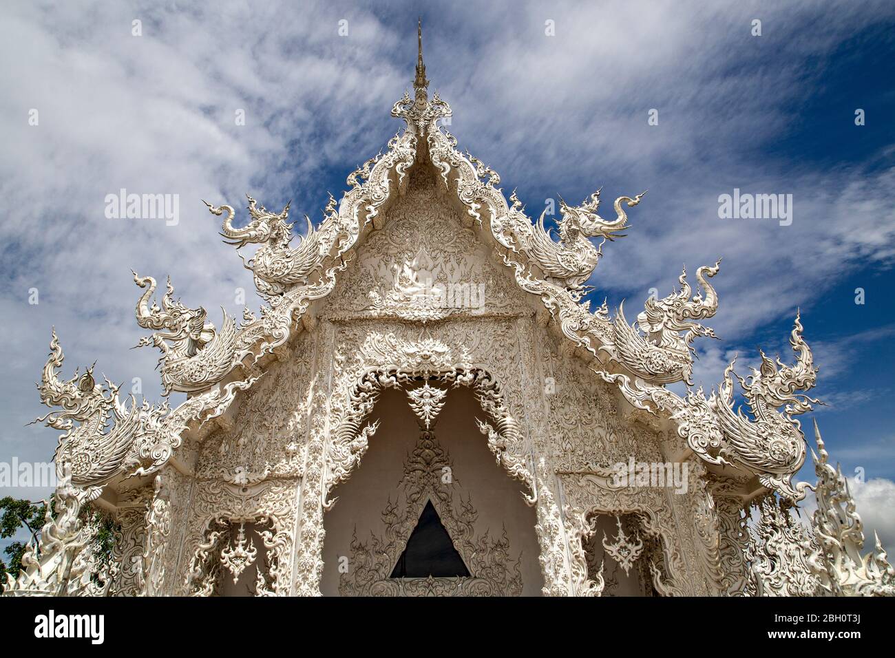 Temple blanc connu sous le nom de Wat Rong Khun avec son reflet dans l'eau, à Chiang Rai, Thaïlande. Banque D'Images