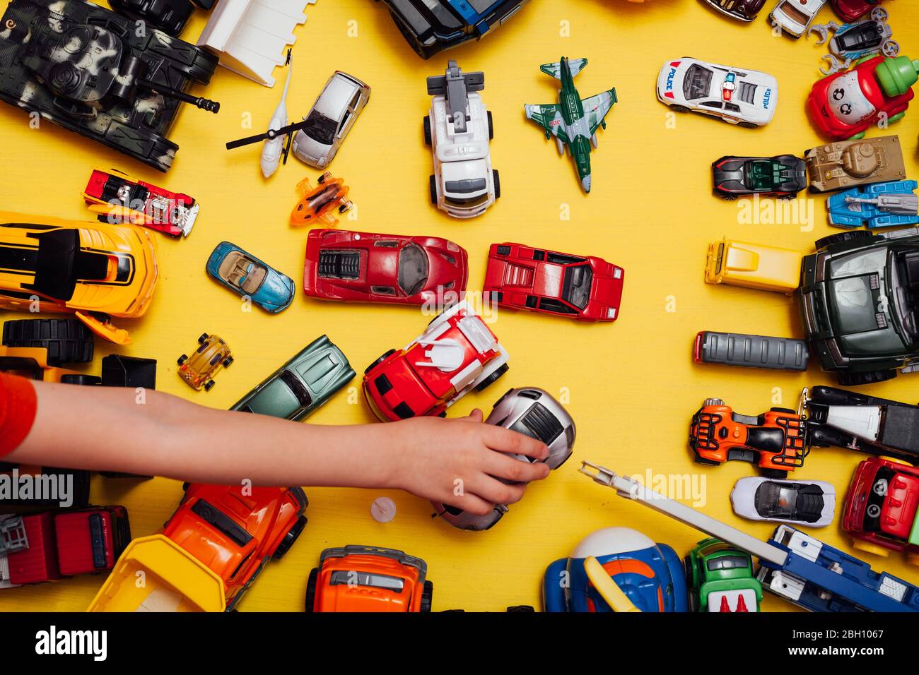 beaucoup de jouets pour enfants pour jouer garçon sur fond jaune Photo  Stock - Alamy