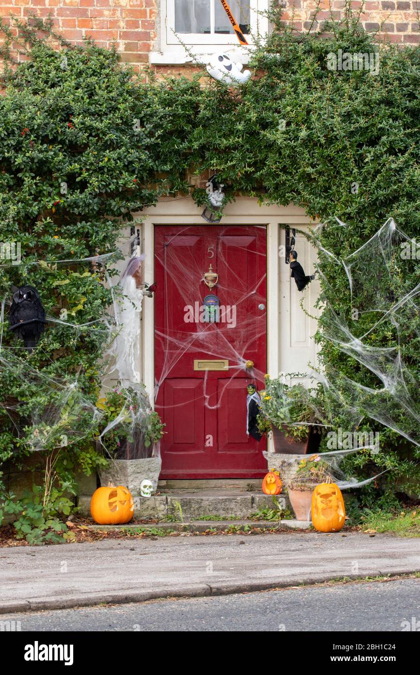 Le devant d'un cottage anglais décoré pour Halloween avec citrouilles et rafles Banque D'Images