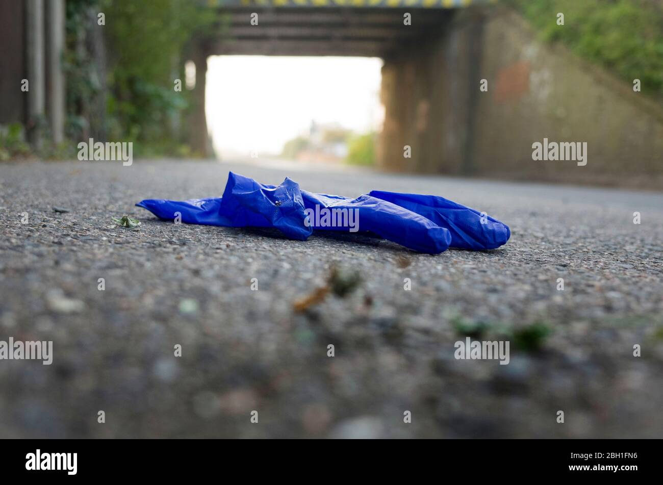 Image de bas niveau de gant en plastique usagé jeté sur la chaussée près du pont dans le Kent, royaume-uni, Angleterre. Banque D'Images