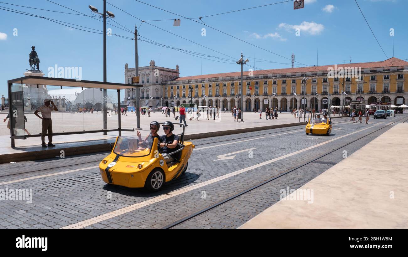 Les touristes qui conduisent des scooters de nouveauté pour voir les sites de Lisbonne, Portugal, lors d'une journée lumineuse et ensoleillée sur la place Comercio. Banque D'Images