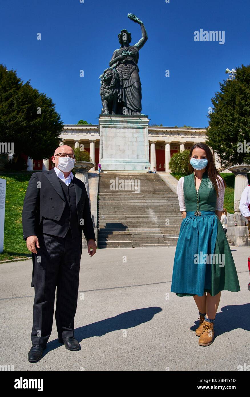 Munich, Allemagne, 22 avril 2020. Présentateur et artiste de cabaret Jürgen KIRNER et présentateur de télévision Karin OBERMAIER posant avec protection de la bouche à la statue de Bavière en raison de l'annulation du festival de bière oktoberfest WIESN 2020 en raison de la maladie du virus Corona (COVID-19) le 22 avril 2020 à Munich, Allemagne. © Peter Schatz / Alay Live News Banque D'Images