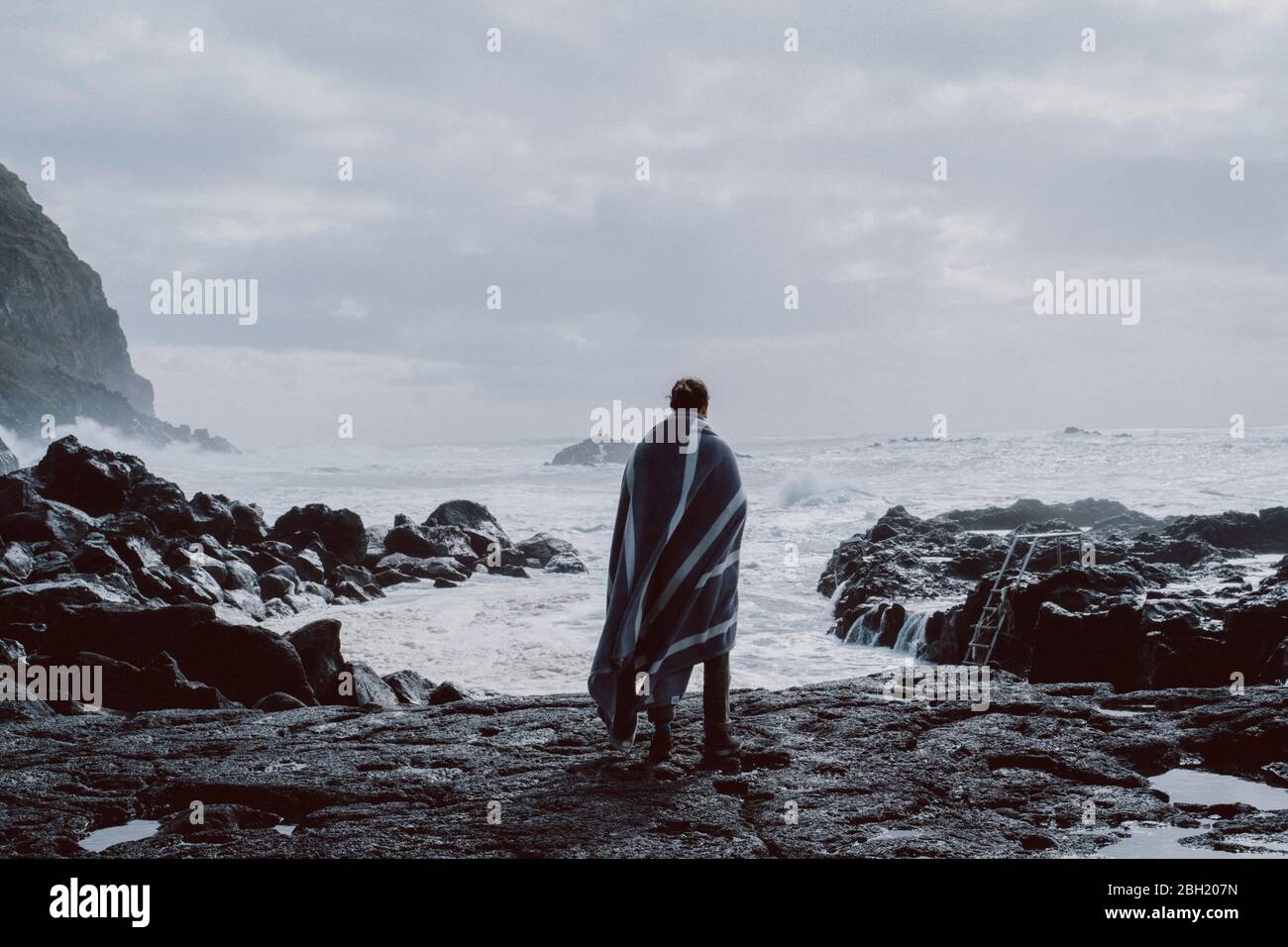 Vue arrière d'un homme debout sur la côte, île de Sao Miguel, Açores, Portugal Banque D'Images
