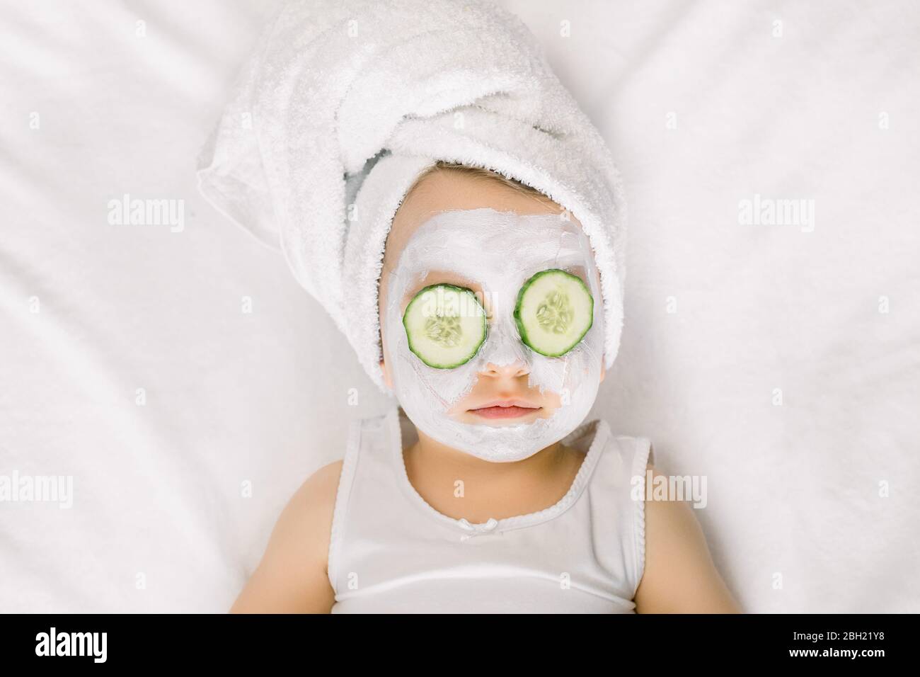 Procedures De Spa Pour Une Petite Fille De Bebe Mignonne Dans Une Serviette De Bain Blanche Avec Concombres Sur Ses Yeux Poses Sur Fond Blanc Bebe Drole Enveloppe Dans Une Serviette Avec