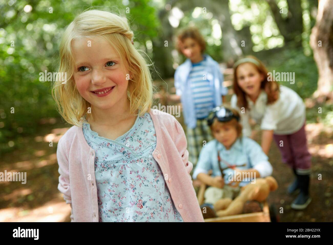 Enfants avec chariot à main jouant dans la forêt Banque D'Images