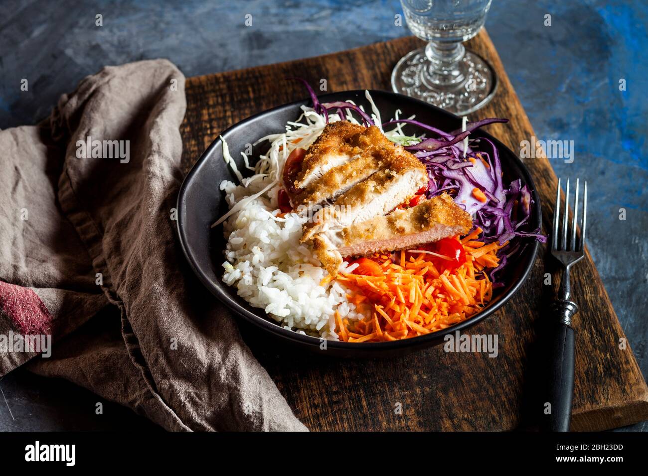 Bol de salade prête à consommer avec chou blanc et rouge, carottes, riz et schnitzel de poulet Banque D'Images