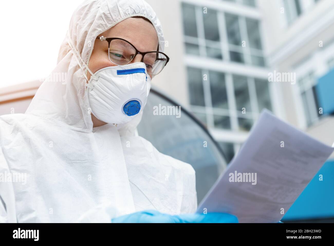 Portrait de femmes fatiguées épuisées médecin, scientifique ou infirmière portant masque de visage et biologique hazmat epi convient à la lecture qui le protocole de traitement ou Banque D'Images