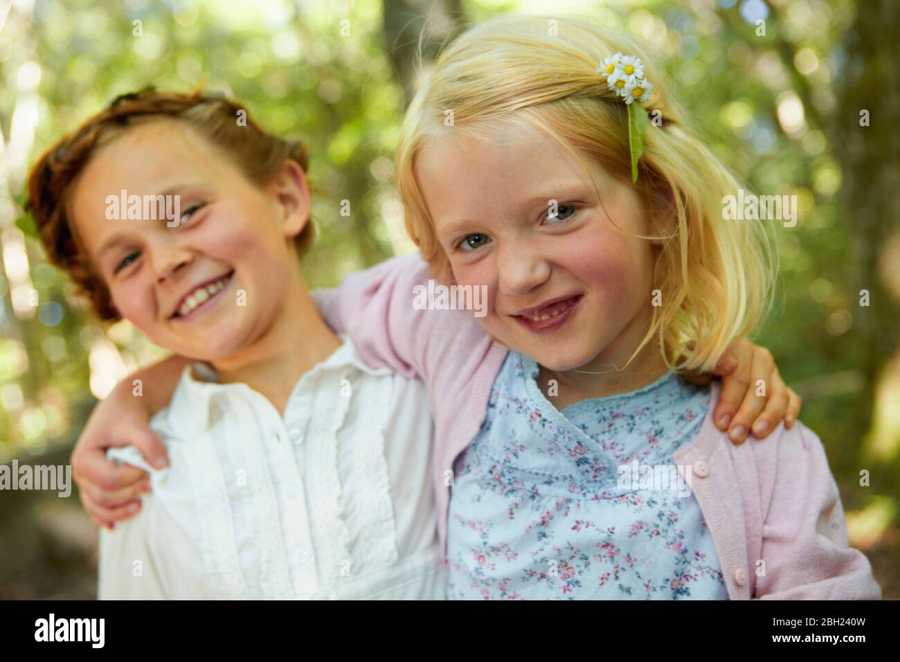 Portrait de filles heureuses qui embrasent dans la forêt Banque D'Images