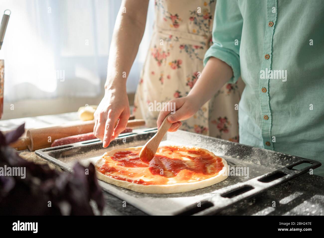 Vue rognée de la sauce tomate étalant pour garçon sur la base de pizzy Banque D'Images