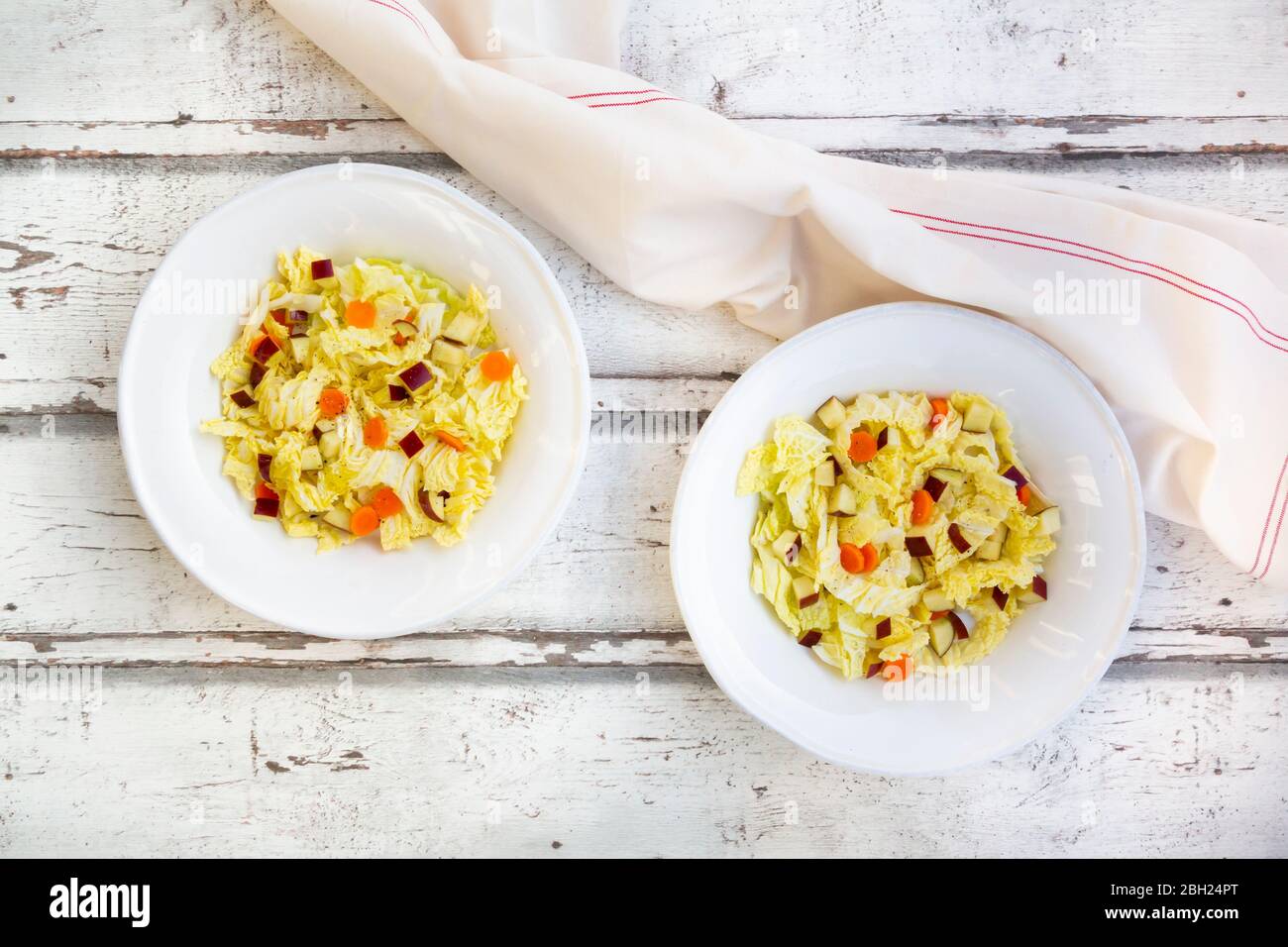 Deux assiettes de salade d'hiver avec chou chinois, pommes et carottes Banque D'Images