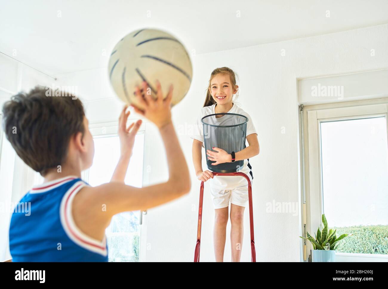 Garçon et fille jouant au basket-ball à la maison Banque D'Images