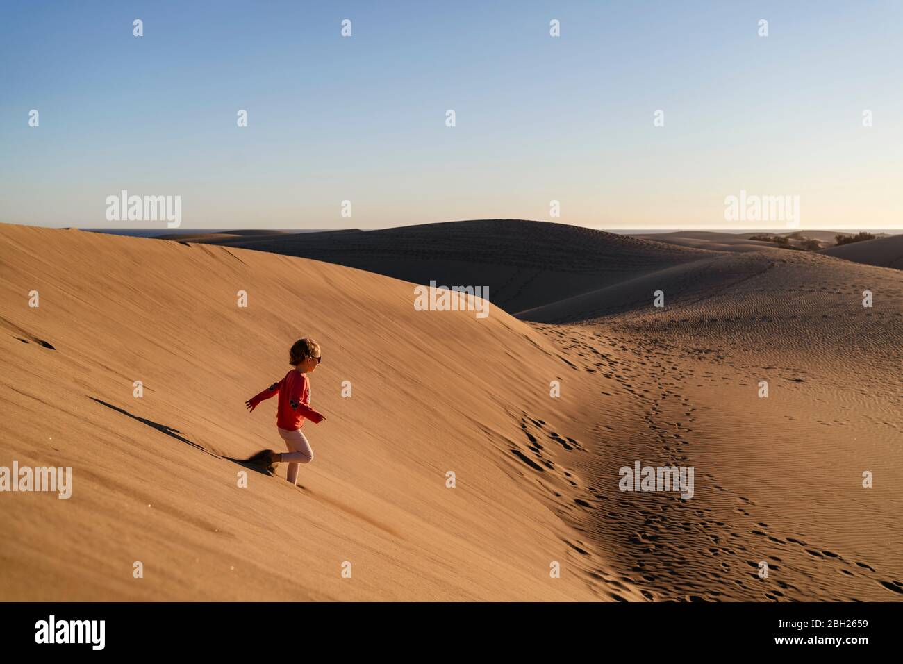 Fille en train de courir sur une dune de sable, Gran Canaria, Espagne Banque D'Images