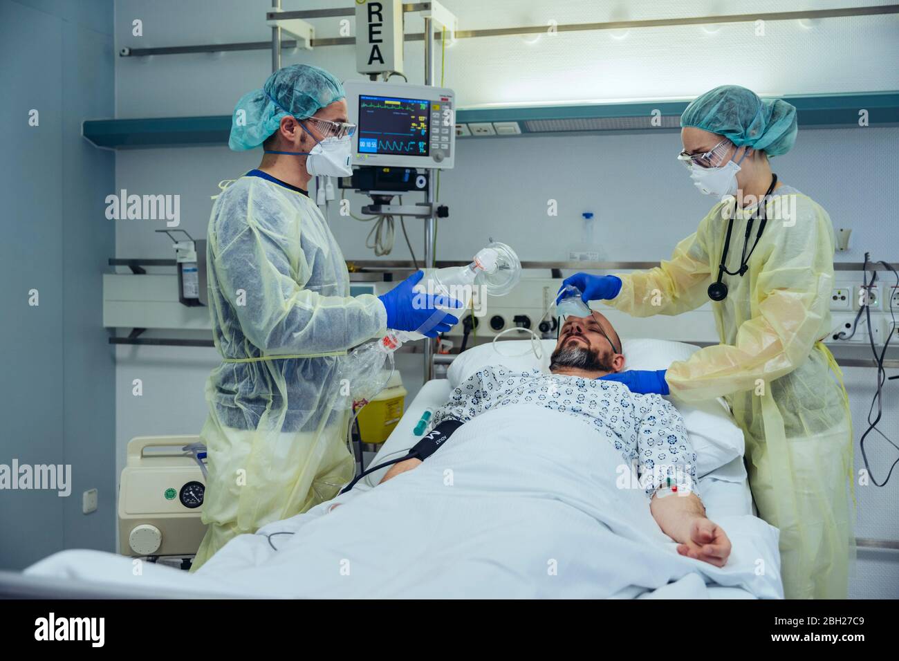 Médecins prenant soin d'un patient dans l'unité de soins d'urgence d'un hôpital changeant la respiration du masque à oxygène au masque à valve à sac Banque D'Images