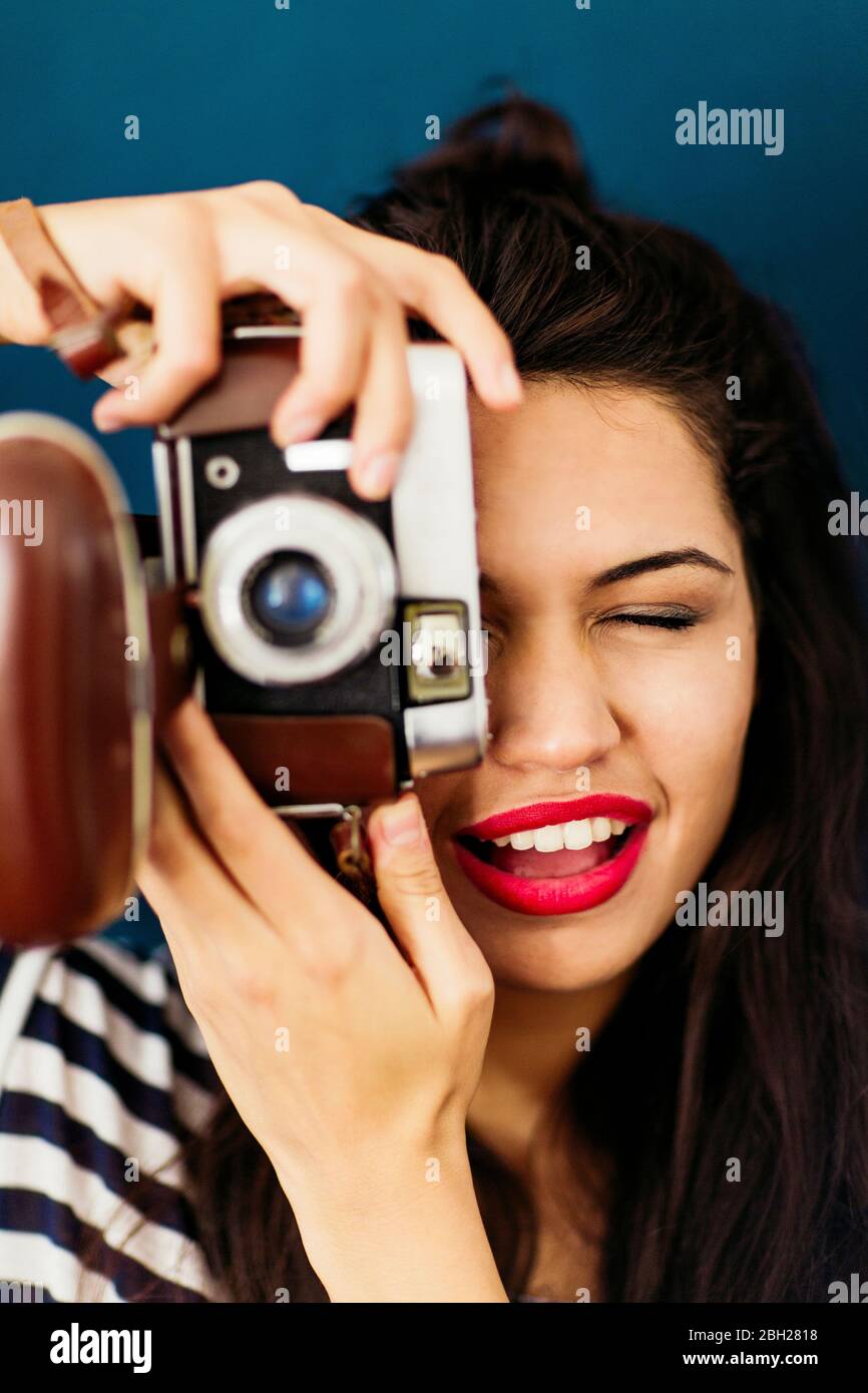 Portrait d'une jeune femme aux lèvres rouges prenant une photo de spectateur avec l'appareil photo Banque D'Images