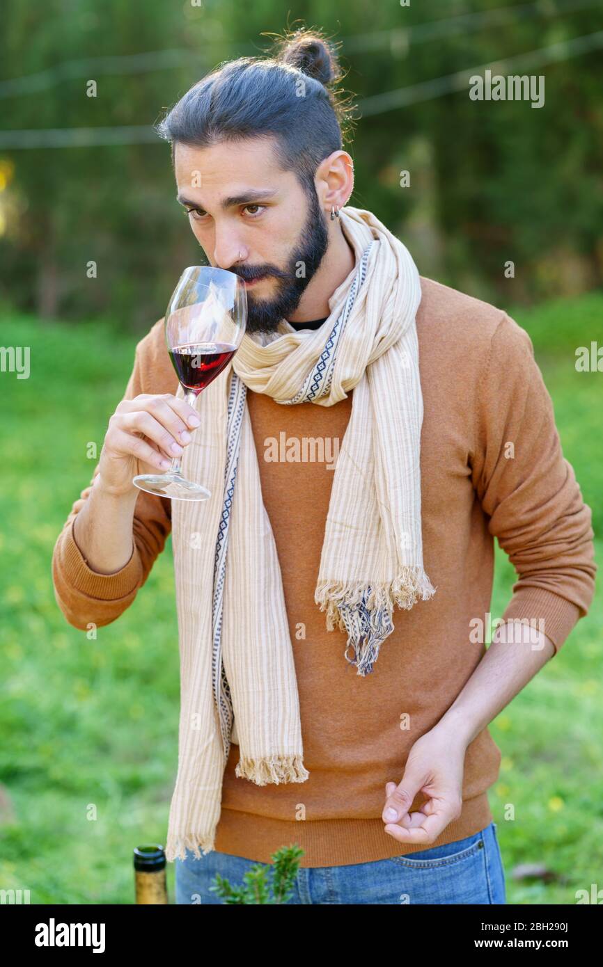 Portrait d'un jeune homme qui goûtant du vin rouge à la campagne Banque D'Images