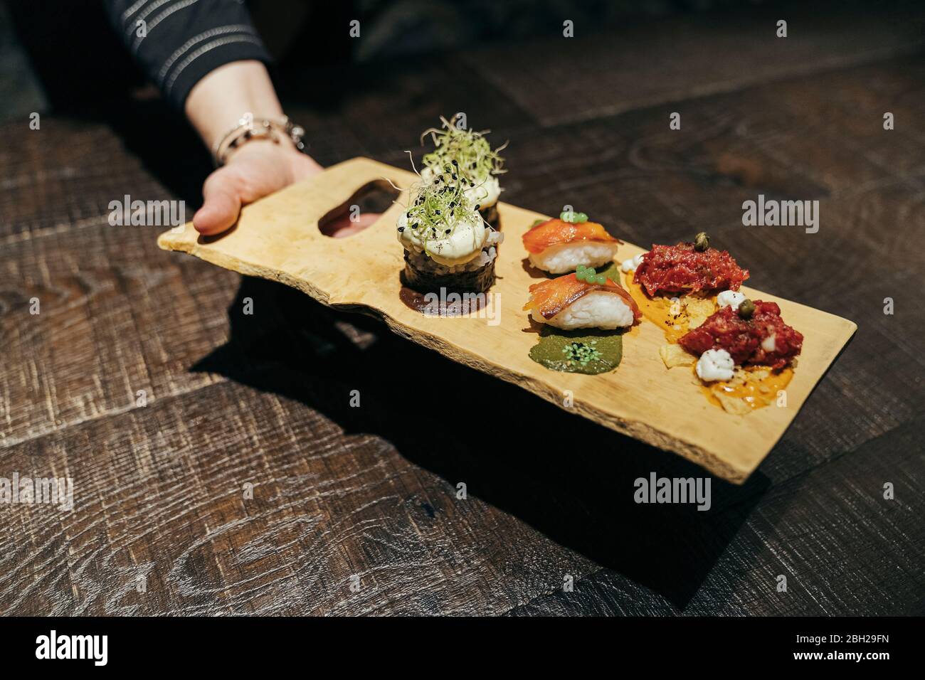 Plats gastronomiques de la Snaish servis à la main sur un tableau Banque D'Images
