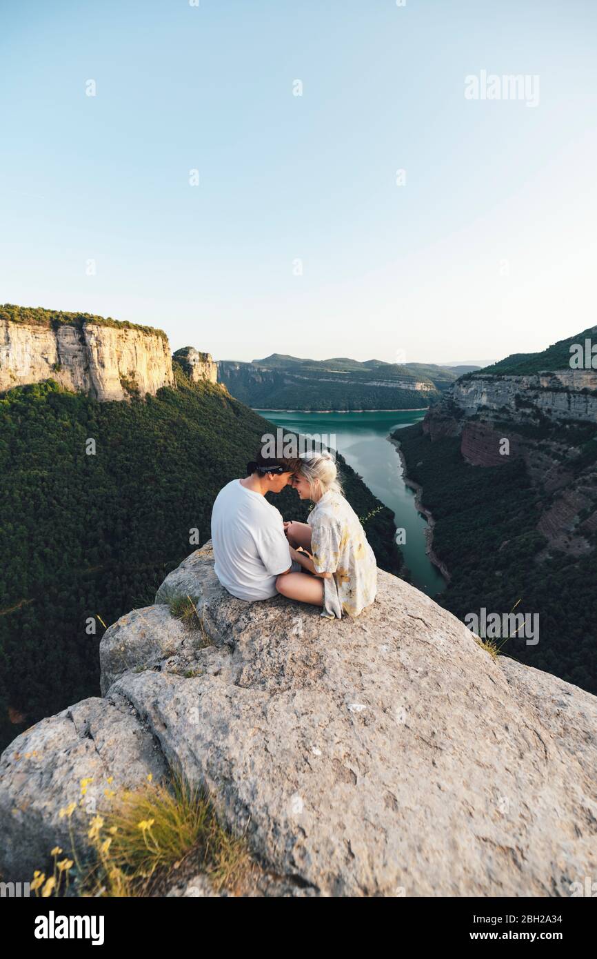 Jeune couple amoureux assis sur le point de vue, réservoir de Sau, Catalogne, Espagne Banque D'Images