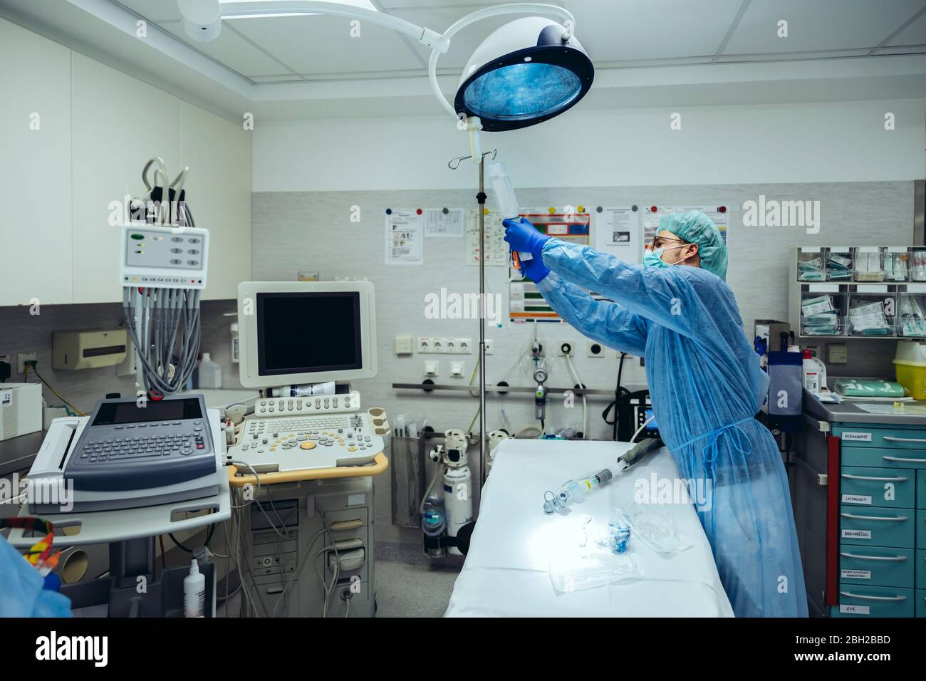 Médecin préparant un perfusion IV dans la salle de traumatologie d'un hôpital Banque D'Images