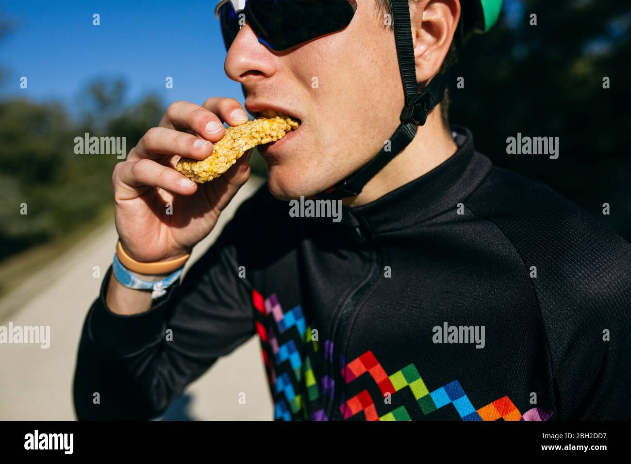 Portrait d'un cycliste mangeant un en-cas pendant une pause le jour ensoleillé Banque D'Images