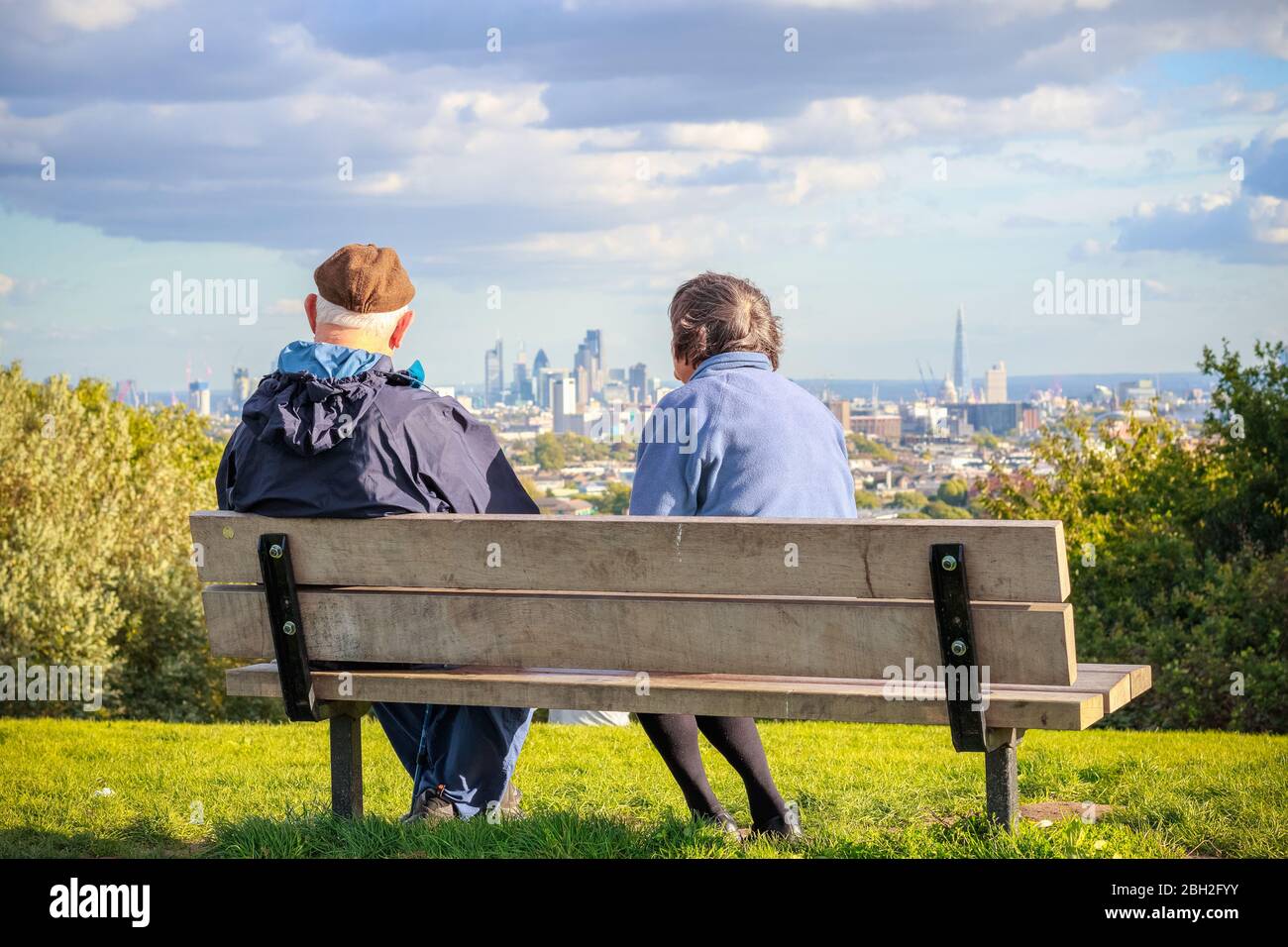 Vue arrière d'un couple senior qui surplombe la ville de Londres depuis la colline du Parlement à Hampstead Heath Banque D'Images