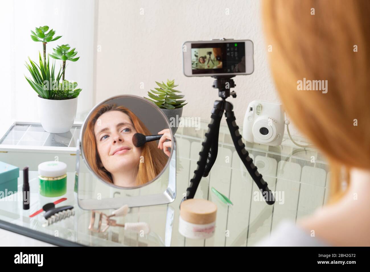 Jeune femme filmant sa routine de beauté à la maison Banque D'Images
