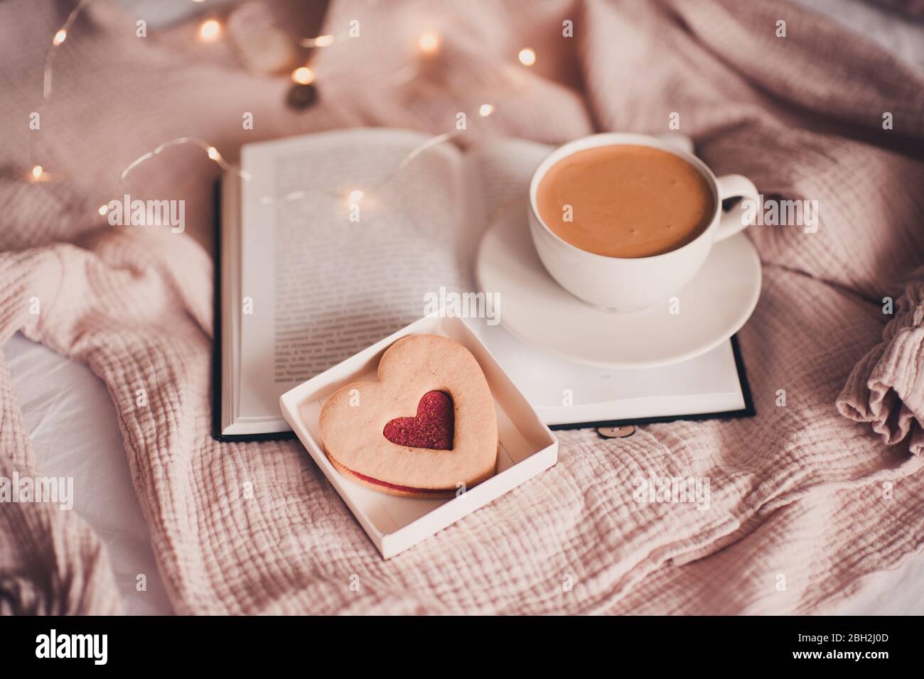 Tasse De Cafe Frais Avec Gateau En Forme De Coeur Sur Livre Ouvert Dans Le Lit Au Dessus De Lumieres Closeup Bonjour Petit Dejeuner Saint Valentin Photo Stock Alamy