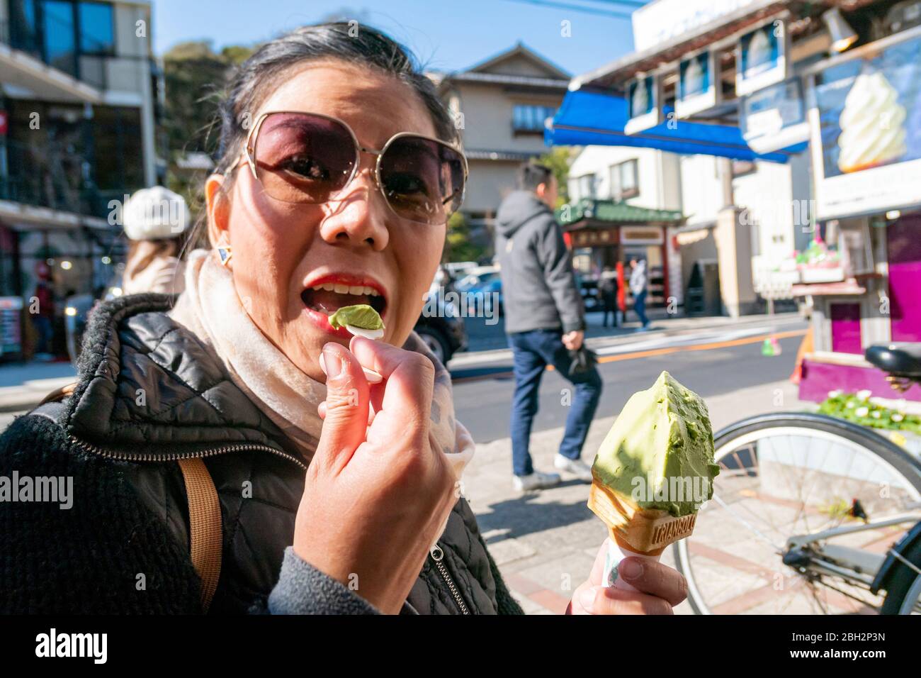 Une femme de tourisme asiatique est en éaing une glace de la célèbre rue vendeur de glace dans la ville de Kamakura où est une vieille ville capitale du Japon. Kana Banque D'Images