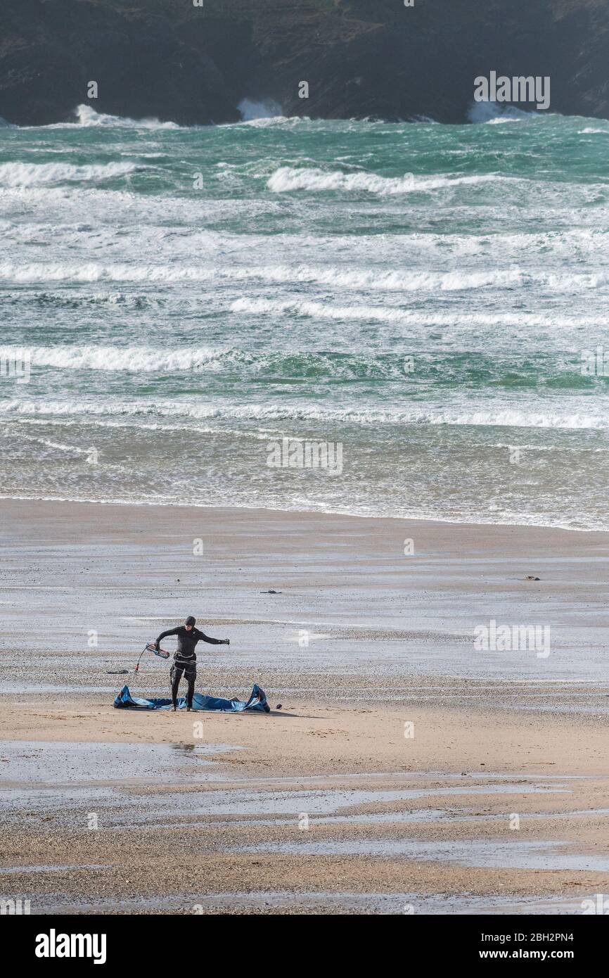 Un surfeur solitaire en kite prépare son équipement de kite surf sur la plage de Fistral à Newquay, en Cornwall. Banque D'Images