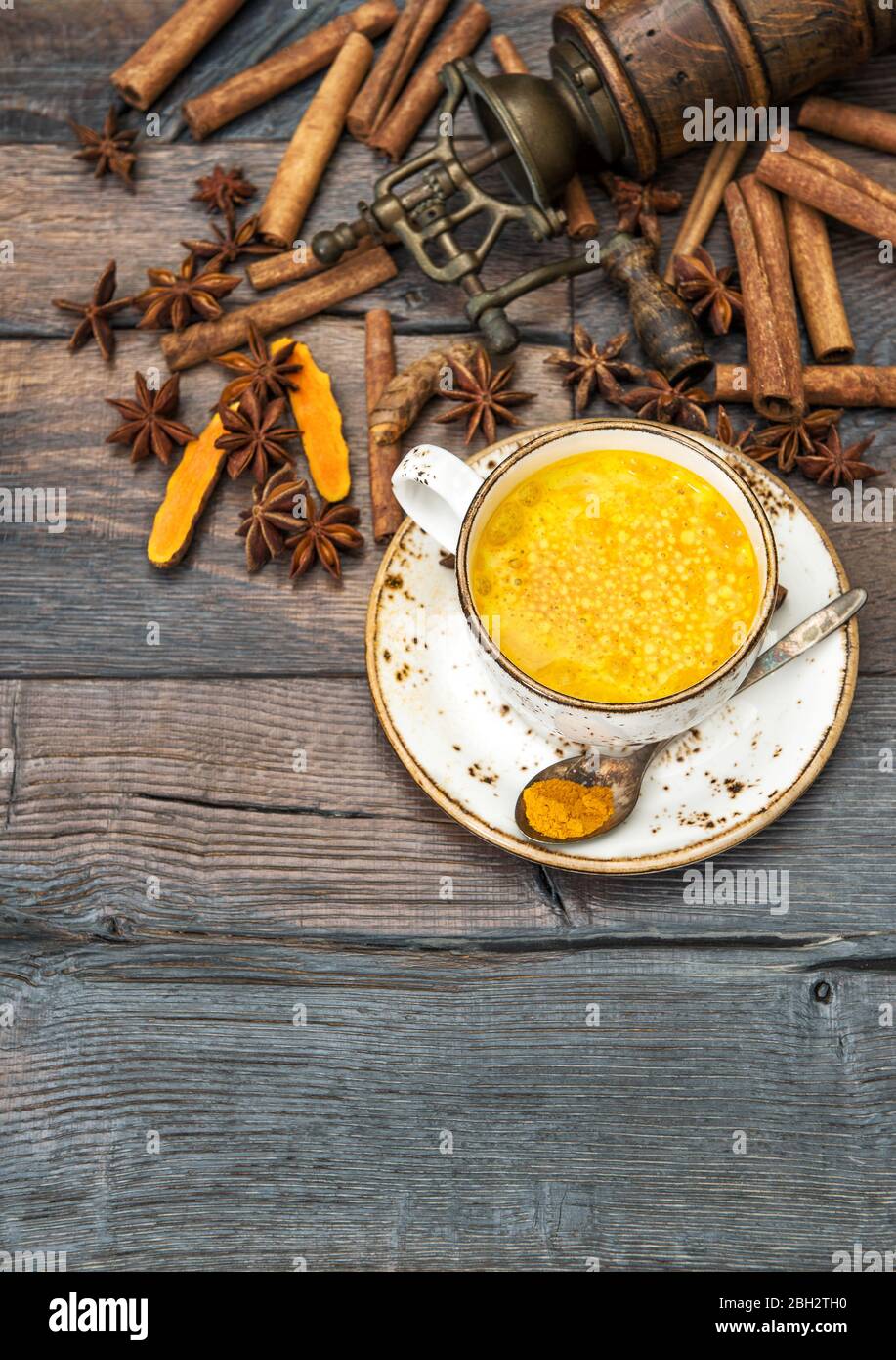 Lait d'or. Boisson chaude au curcuma avec épices sur fond rustique en bois Banque D'Images