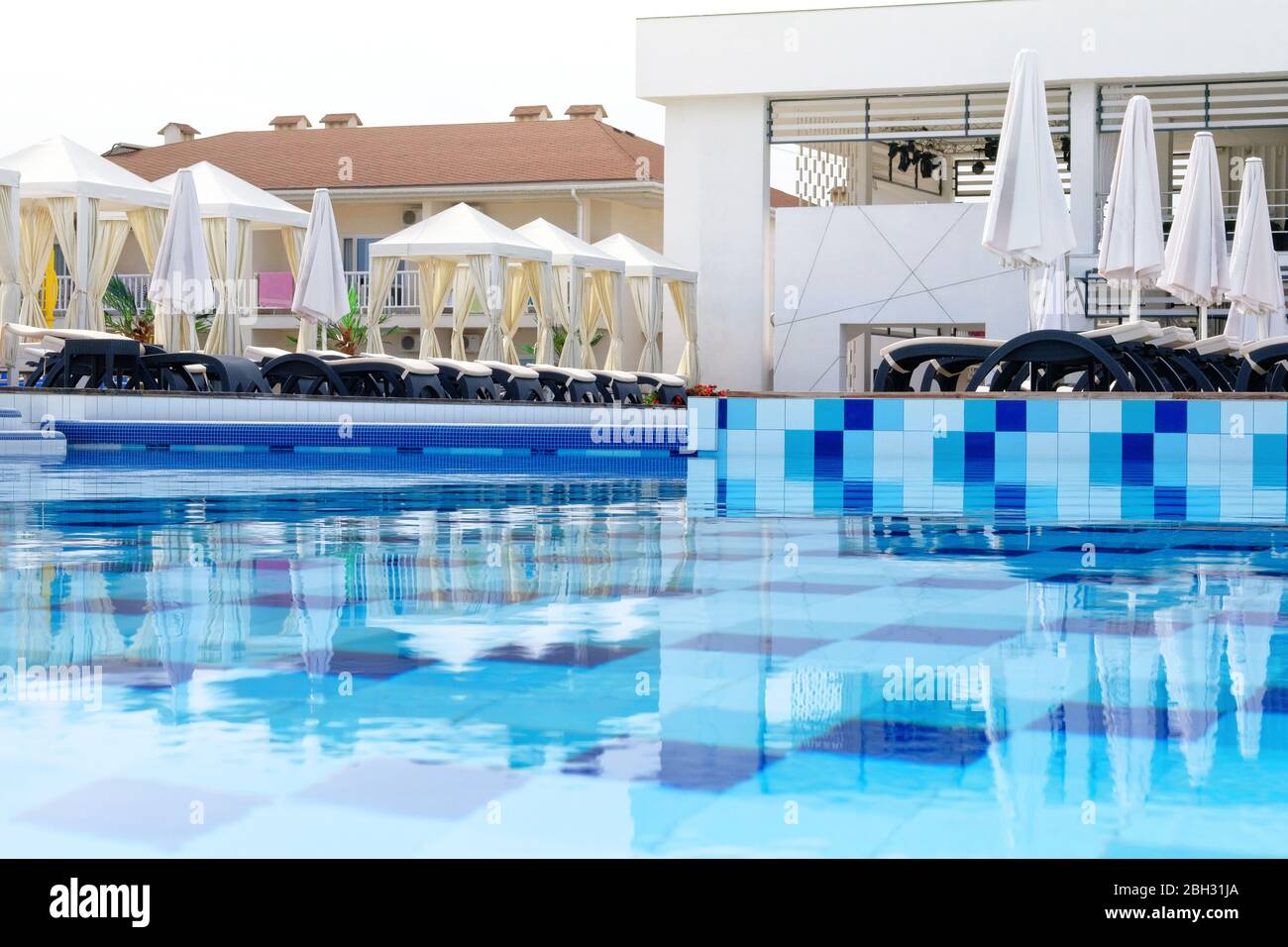 Piscine aquatique avec chaises longues et parasols dans un complexe de luxe. Spa et détente en vacances et en vacances. Banque D'Images