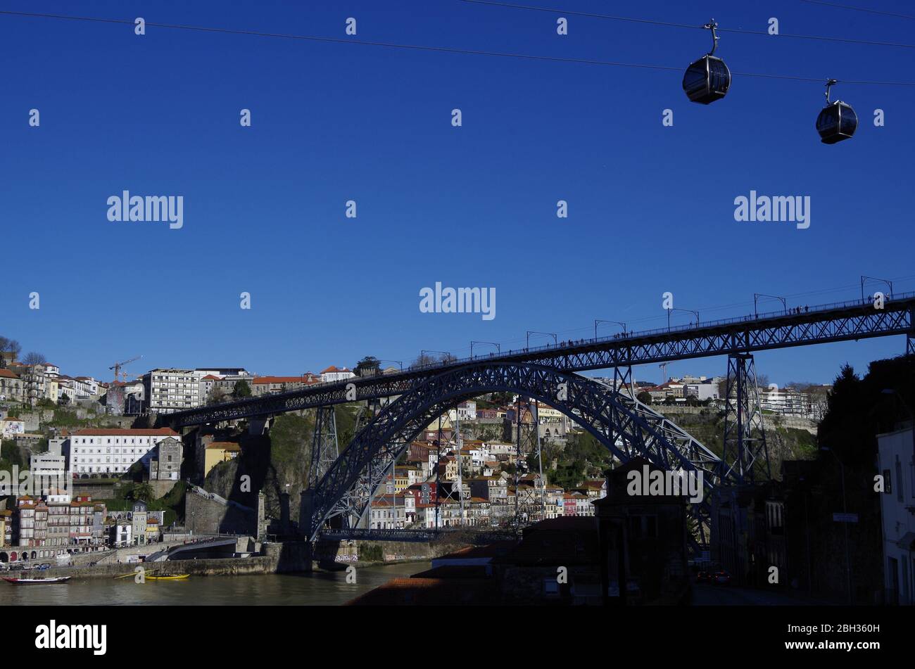L'arche de métal à double pont historique Ponte Luis I enjambant la vallée à flancs escarpés du fleuve Douro à Porto, au Portugal, avec des téléphériques au-dessus Banque D'Images