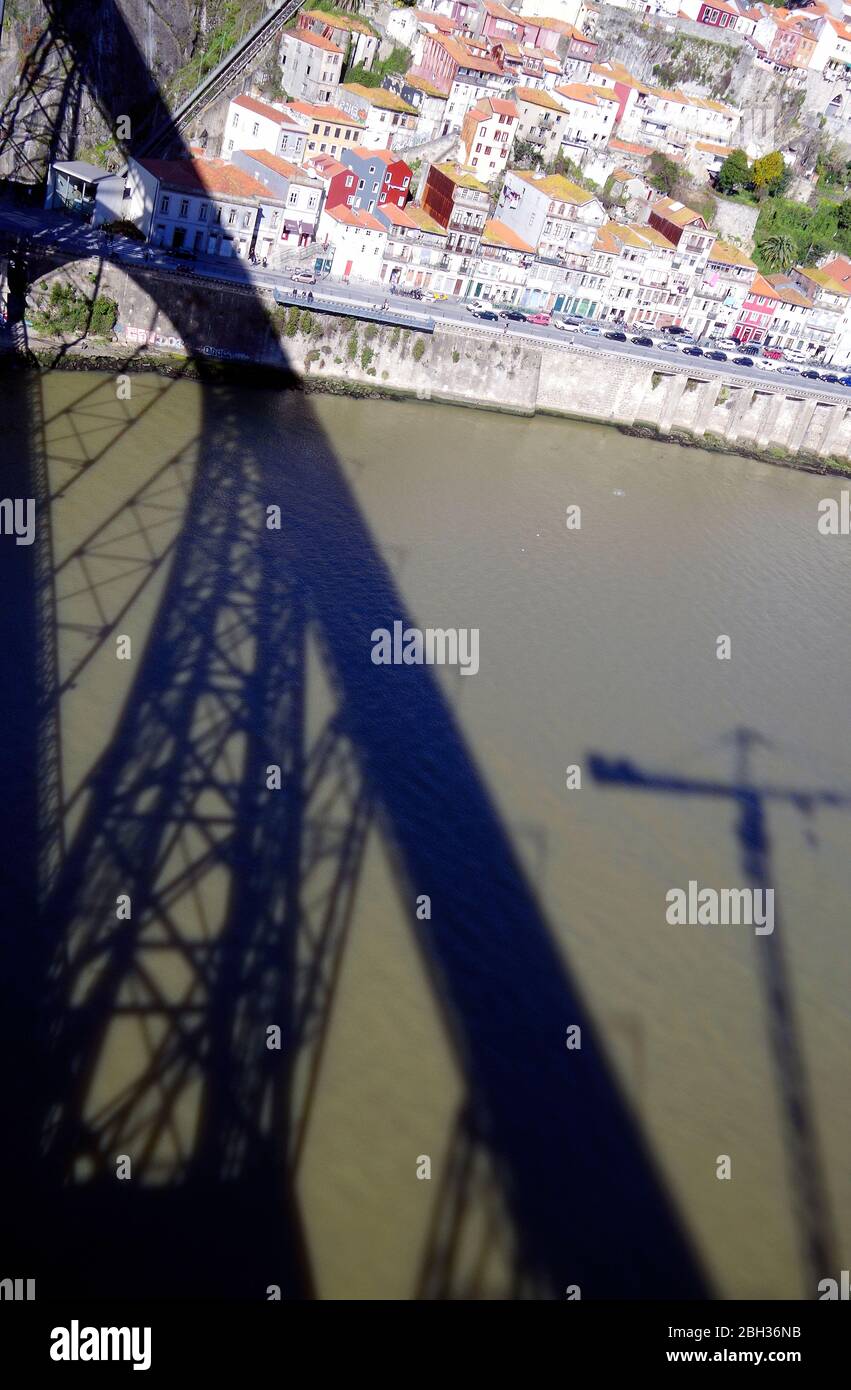 Ombres de l'arche métallique Ponte Luis I, coulées sur les eaux boueuses du fleuve Douro en passant par la ville de Porto, Portugal Banque D'Images