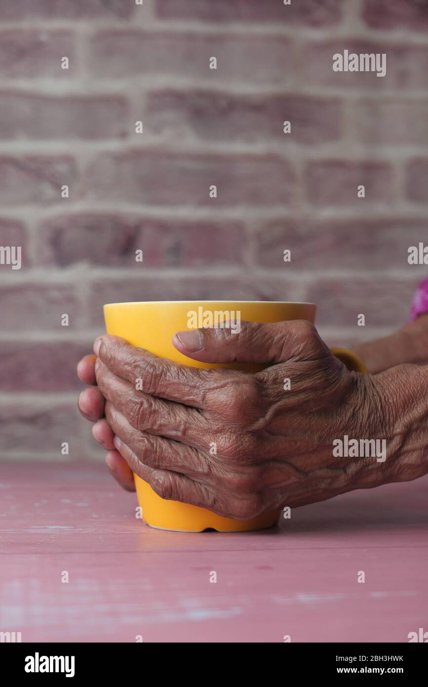 mug femme senior tenant main jaune, Banque D'Images