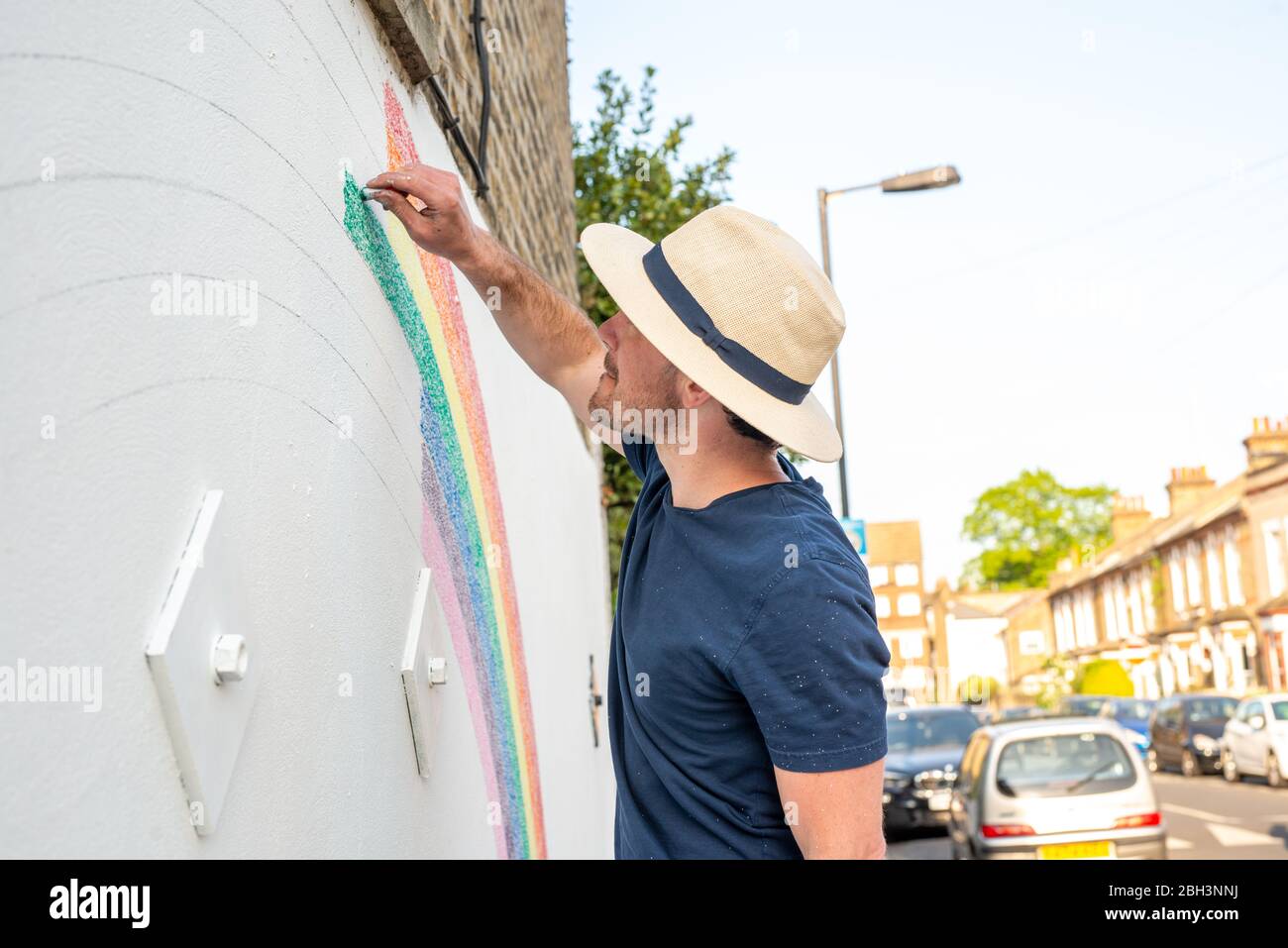 Camberwell, Londres, Royaume-Uni. 23 avril 2020. Louis Young dessine une murale d'un arc-en-ciel sur le mur de sa maison pour vous remercier du NHS pour avoir pris soin de son père. Son père est sorti de l'hôpital aujourd'hui après des semaines d'une maladie pulminaire mais non covid-19. Crédit: Tom Leighton/Alay Live News Banque D'Images