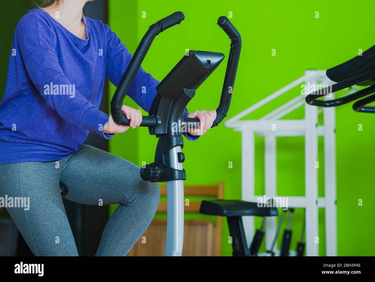 Femme caucasienne vélo stationnaire d'équitation dans la salle de gym. Banque D'Images