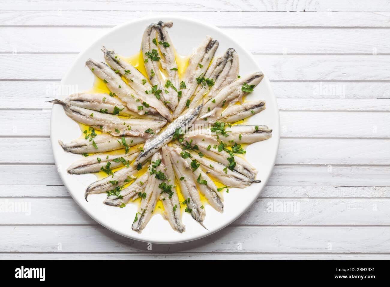 Anchois marinés au vinaigre avec huile d'olive et persil. Tapa espagnole traditionnelle Banque D'Images