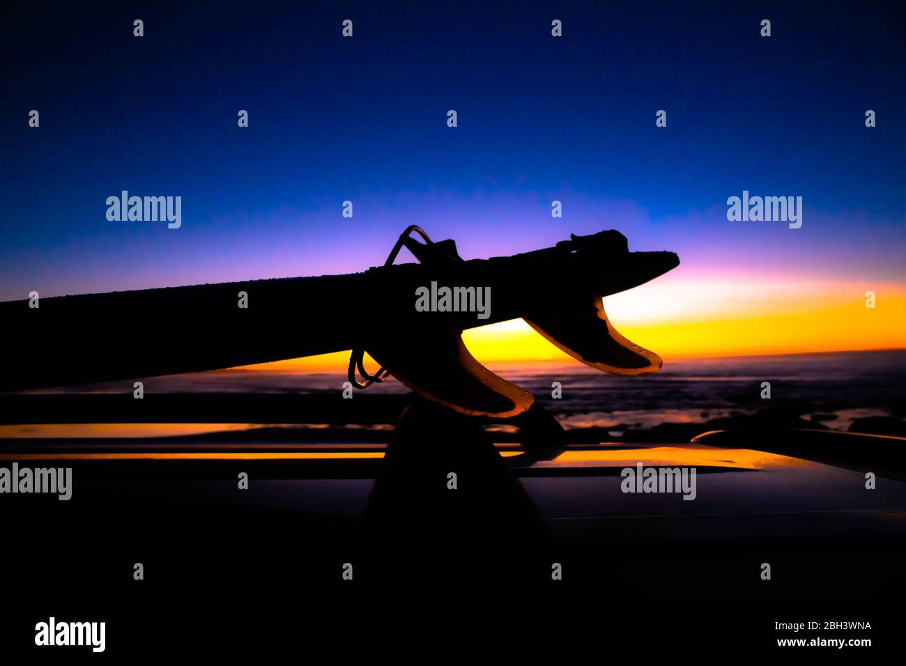 Silhouette de planche de surf au soleil sur un véhicule Banque D'Images