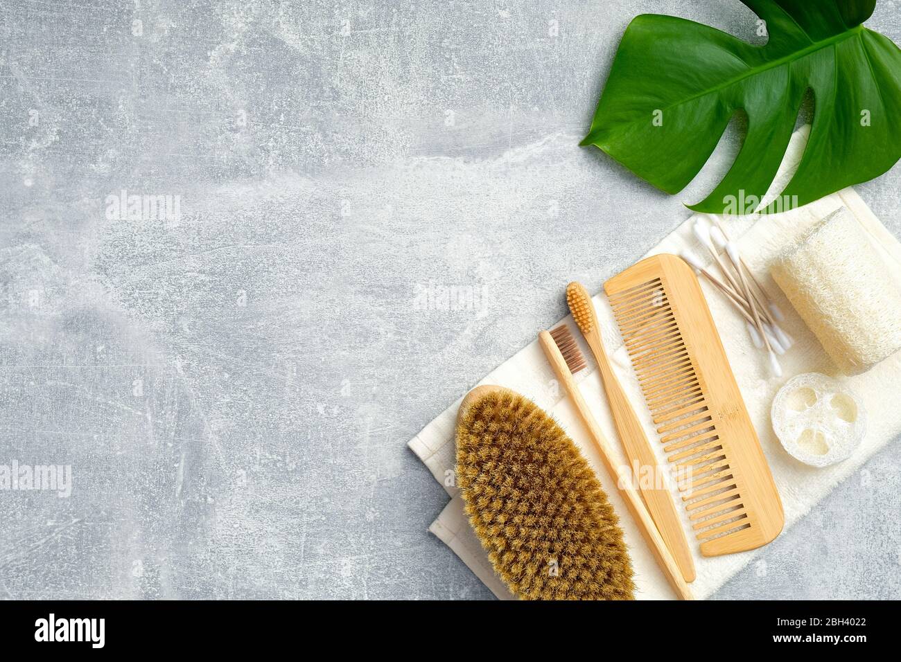 Accessoires de bain et produits de beauté naturels AVEC feuilles vertes sur fond de pierre. Hygiène personnelle et concept de traitement du corps. Plat, vue du dessus Banque D'Images