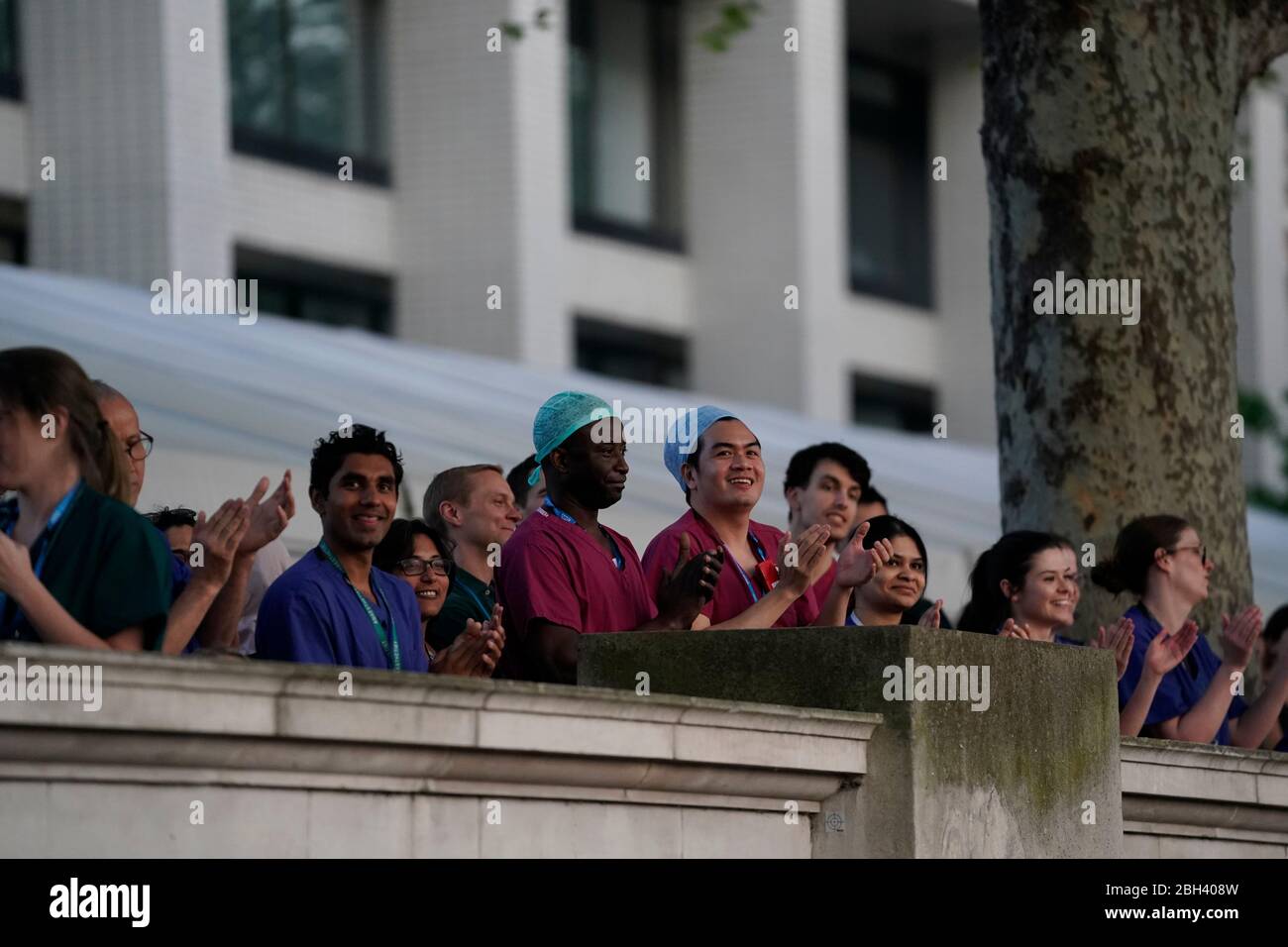 Le personnel de l'hôpital se tient à l'extérieur de l'hôpital St Thomas de Londres pour saluer les héros locaux au cours de l'initiative nationale Clap for Carers de jeudi visant à reconnaître et à soutenir les travailleurs et les soignants du NHS qui luttent contre la pandémie de coronavirus. Banque D'Images