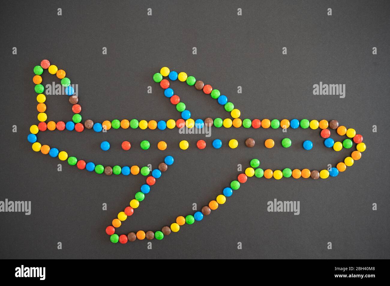 Les bonbons M&M qui forment un avion sur fond noir Banque D'Images