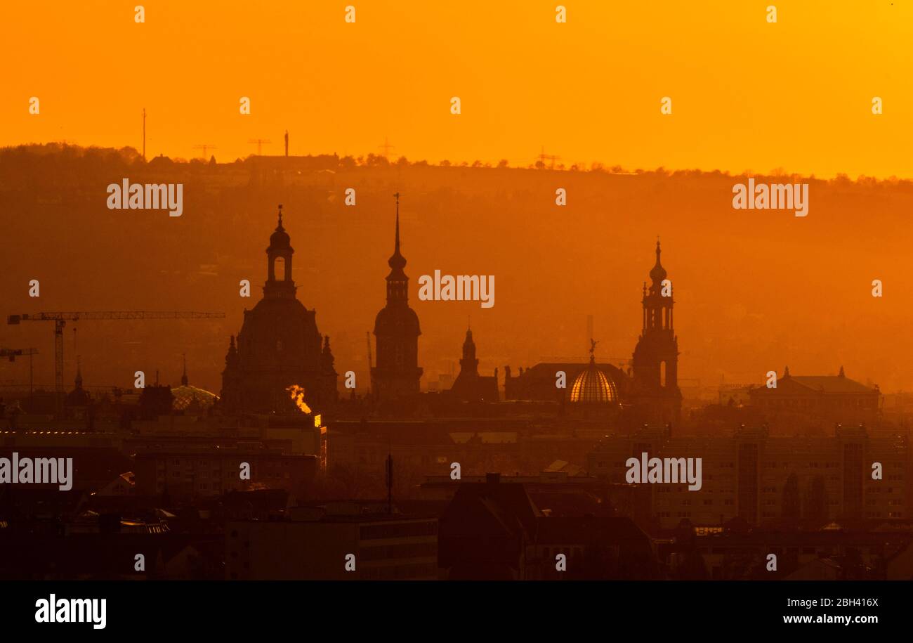 Dresde, Allemagne. 23 avril 2020. Le soleil se couche dans la soirée à l'horizon derrière le centre-ville avec la Frauenkirche, la Hausmannsturm, la Ständehaus, le dôme de l'Académie des Arts avec l'ange 'Faca', la Hofkirche et l'Opéra Semper. Crédit: Robert Michael/dpa-Zentralbild/dpa/Alay Live News Banque D'Images