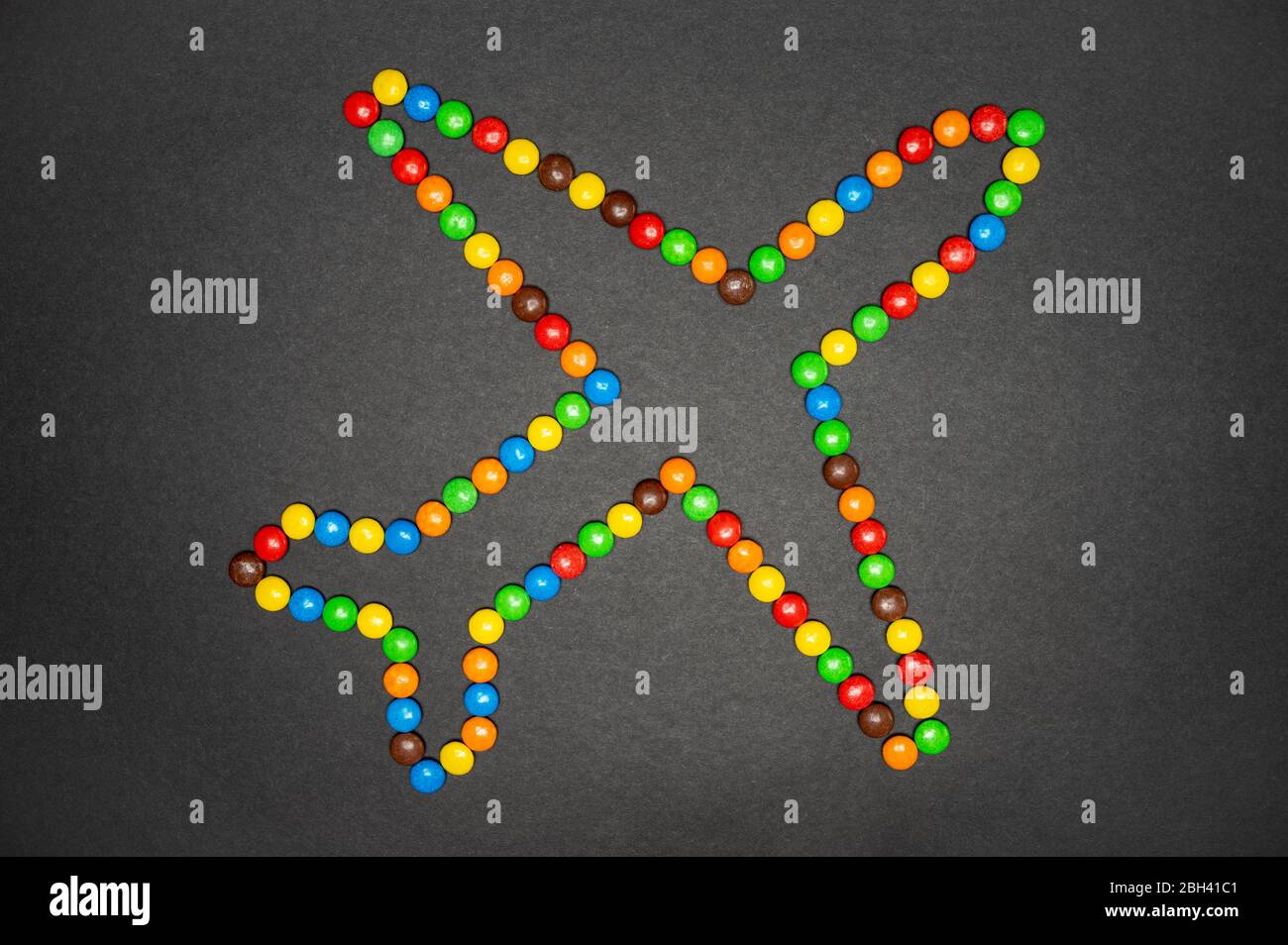 Les bonbons M&M qui forment un avion sur fond noir Banque D'Images
