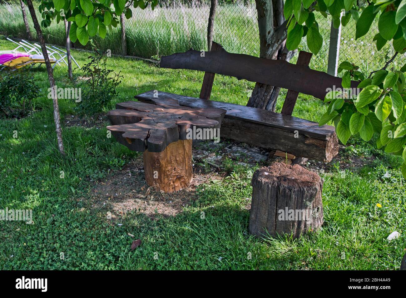 Endroit calme et calme dans un petit parc avec un banc et une table en bois. Le banc et la table à l'ombre attendent les visiteurs. Banque D'Images