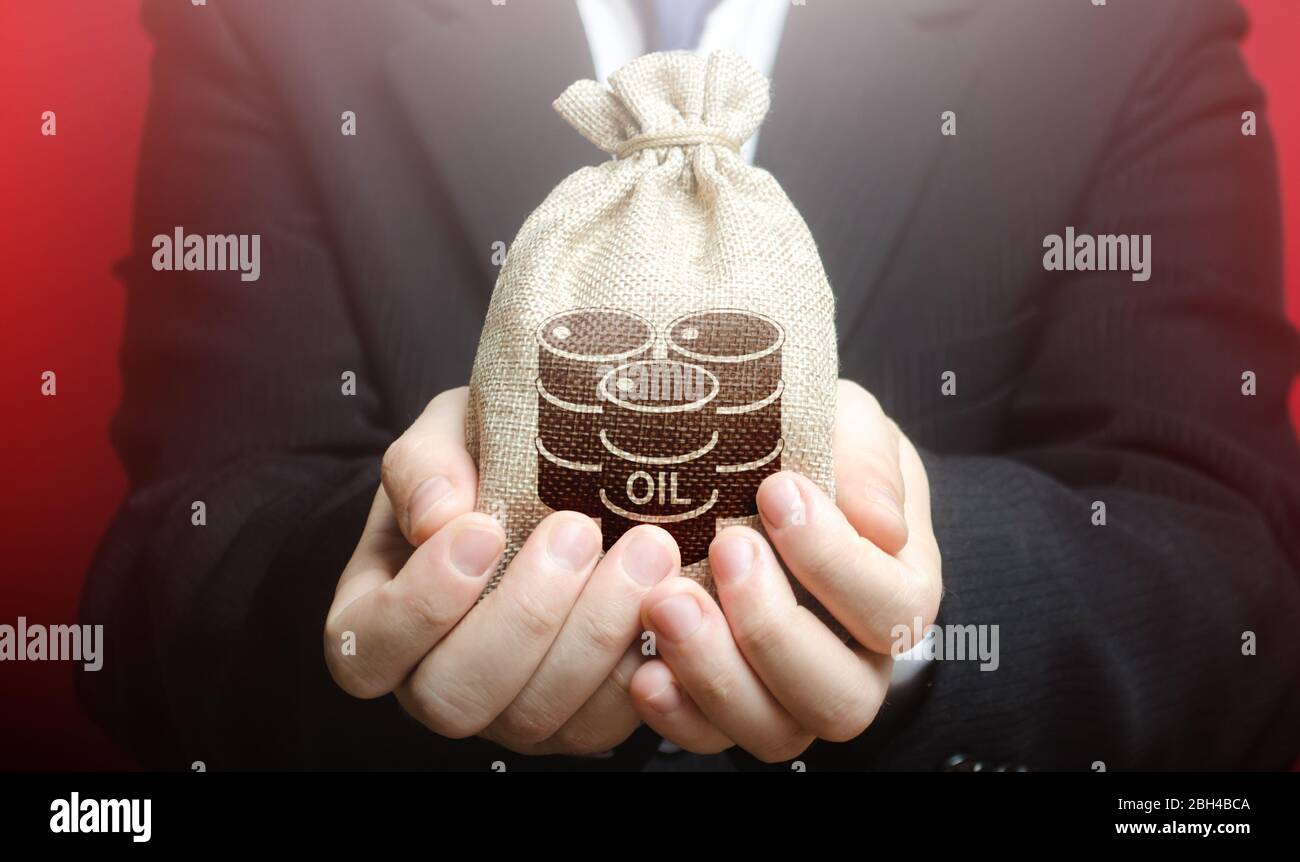 Un homme tient un sac avec des barils de pétrole. Proposer l'achat de pétrole et de contrats à terme à prix compétitif, des réductions et des primes. Report du paiement. Nega Banque D'Images